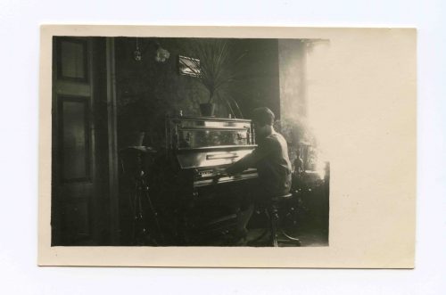 Gražutė Šlapelytė skambina pianinu savo namuose Pilies g. 1928 m. Marija Piaseckaitė-Šlapelienė šį Muhlbach firmos pianiną įsigijo būdama dar 18-likos. Jis stovėjo šeimos namuose Saracėnų gatvėje (1926 m. Šlapeliai persikėlė į namą Pilies g. 40), kur pas Jurgį Šlapelį pasimokyti lietuvių kalbos ateidavo įvairaus amžiaus vilniečių. Tarp besimokančiųjų buvo ir Mikalojus Konstantinas Čiurlionis, kuris mėgdavo prisėsti ir paskambinti šiuo pianinu. Juo taip pat pagrodavo artimas Šlapelių šeimos draugas kompozitorius Mikas Petrauskas.