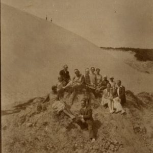 Šlapeliai su kompanija Nidos kopose. 1929 m. Antroje eilėje pirmas iš dešinės sėdi Kazys Graužinis, šalia jo – Laimutė. Už 9 dienų įvyks judviejų sutuoktuvės. Aukščiau už Laimutės sėdi Skaistutis, šalia jo – mama Marija Šlapelienė. Vidurinioji sesuo Gražutė – viršutinėje eilėje trečia iš kairės.