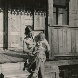 Laimutė Šlapelytė-Graužinienė su dukrele Laimute ant kelių. 1931 m. Šlapelių dukra Laimutė vasaroja savo tėvų vasarnamyje Valakampiuose. Tuo metu jos vyras Kazimieras Graužinis ėjo Lietuvos prezidento Antano Smetonos sekretoriaus pareigas (1929–1932 m.).